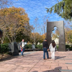 People stand in front of a veteran's memorial