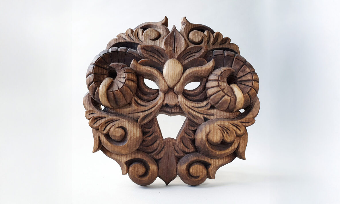 Carved wooden artwork with stylized foliage forming a face by Anya Kalk