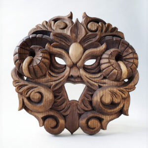 Carved wooden artwork with stylized foliage forming a face by Anya Kalk