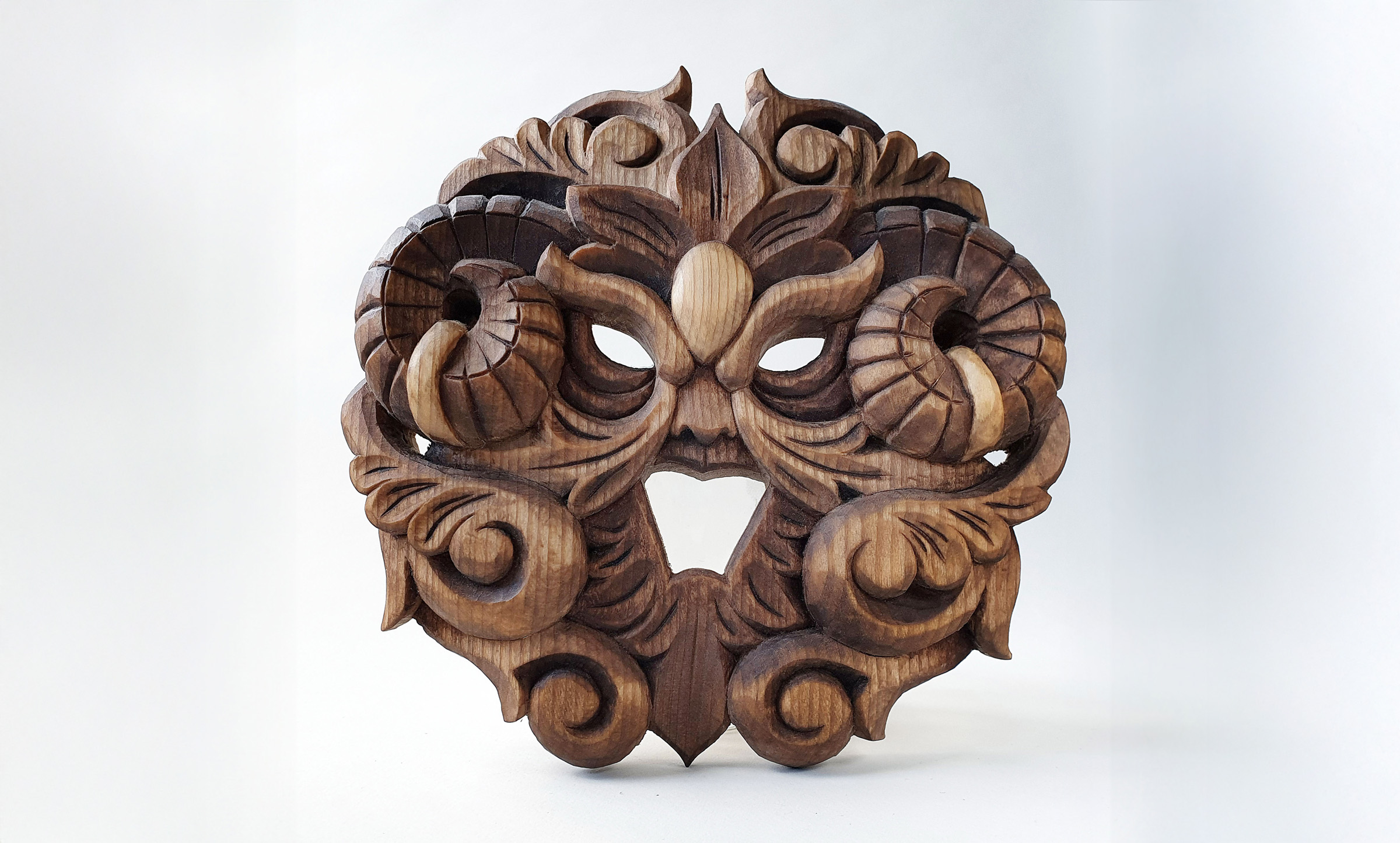 Carved wooden artwork with stylized foliage forming a face by Anya Kalk